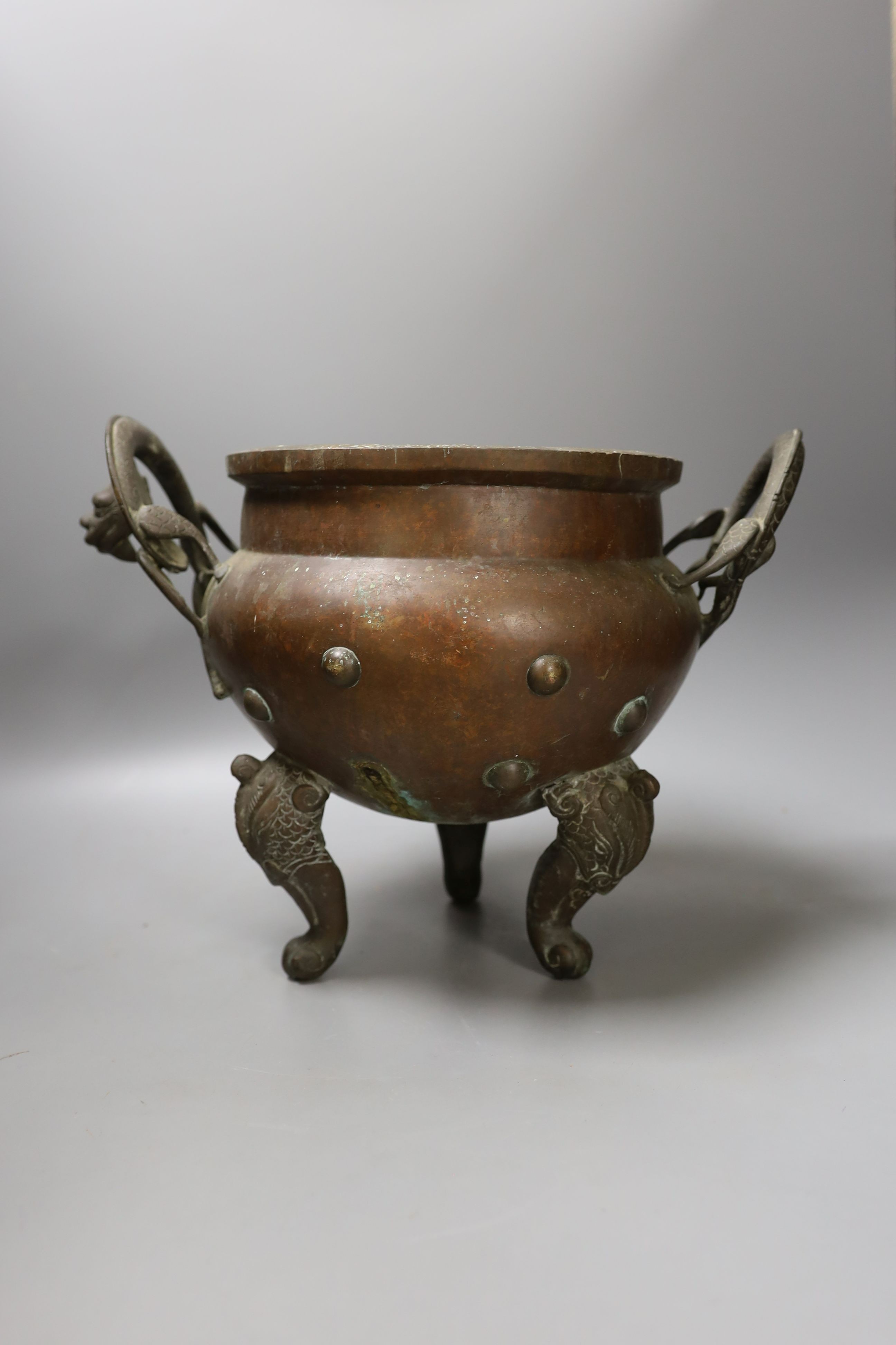 An Oriental two handled elephant footed bronze bowl, 24 cms high not including handles.